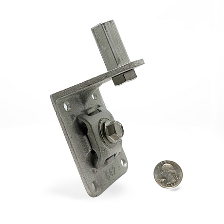 Cast Aluminum Offset Wall Point Base with 5/8” compatibility shown with a quarter for size reference. This base features a 2” offset point adapter and four mounting holes, ideal for lightning protection systems on masonry and metal surfaces. Ensures secure cable contact for main-sized cables, meeting UL Listed Lightning Protection standards. Provided by American Rod Company.